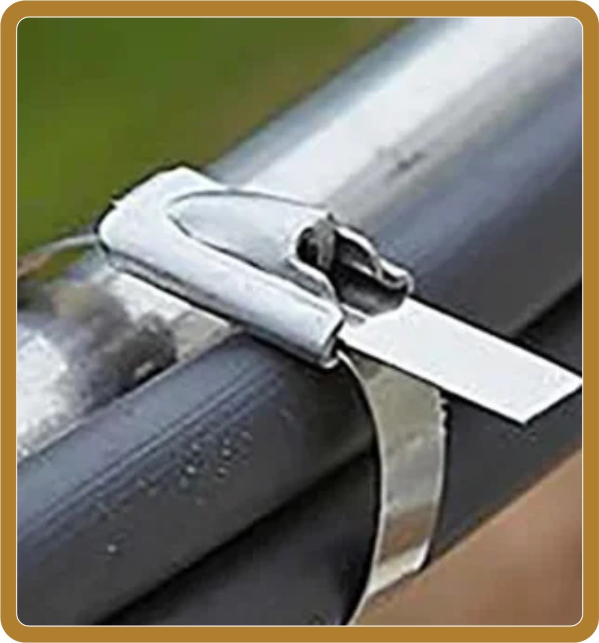 Stainless steel cable tie clamp securing bundled cables to metal pipe with green background demonstrating professional cable management and fastening solution